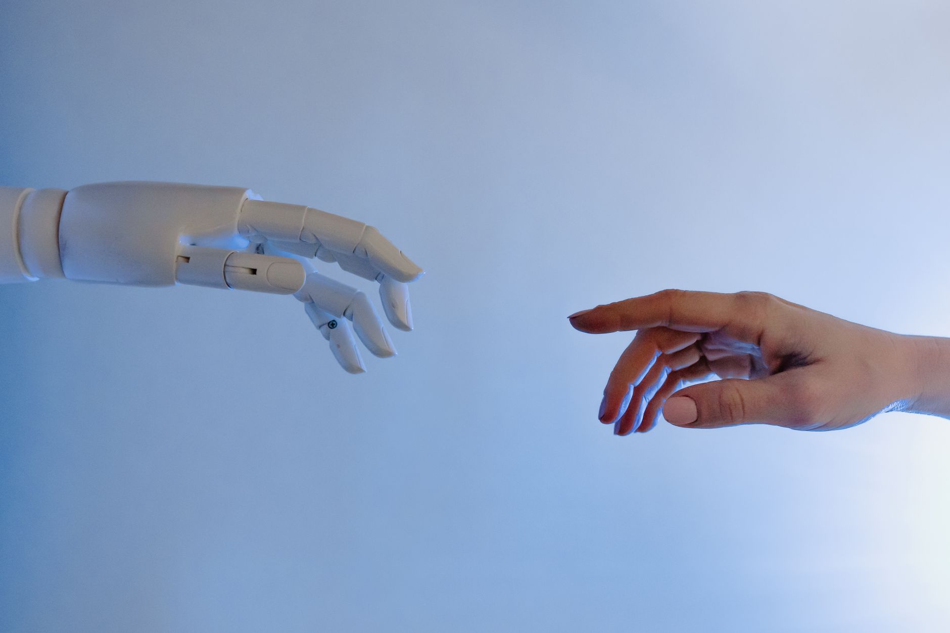 Main humaine tendue vers une main robotique, symbolisant la rencontre entre l'IA et le droit