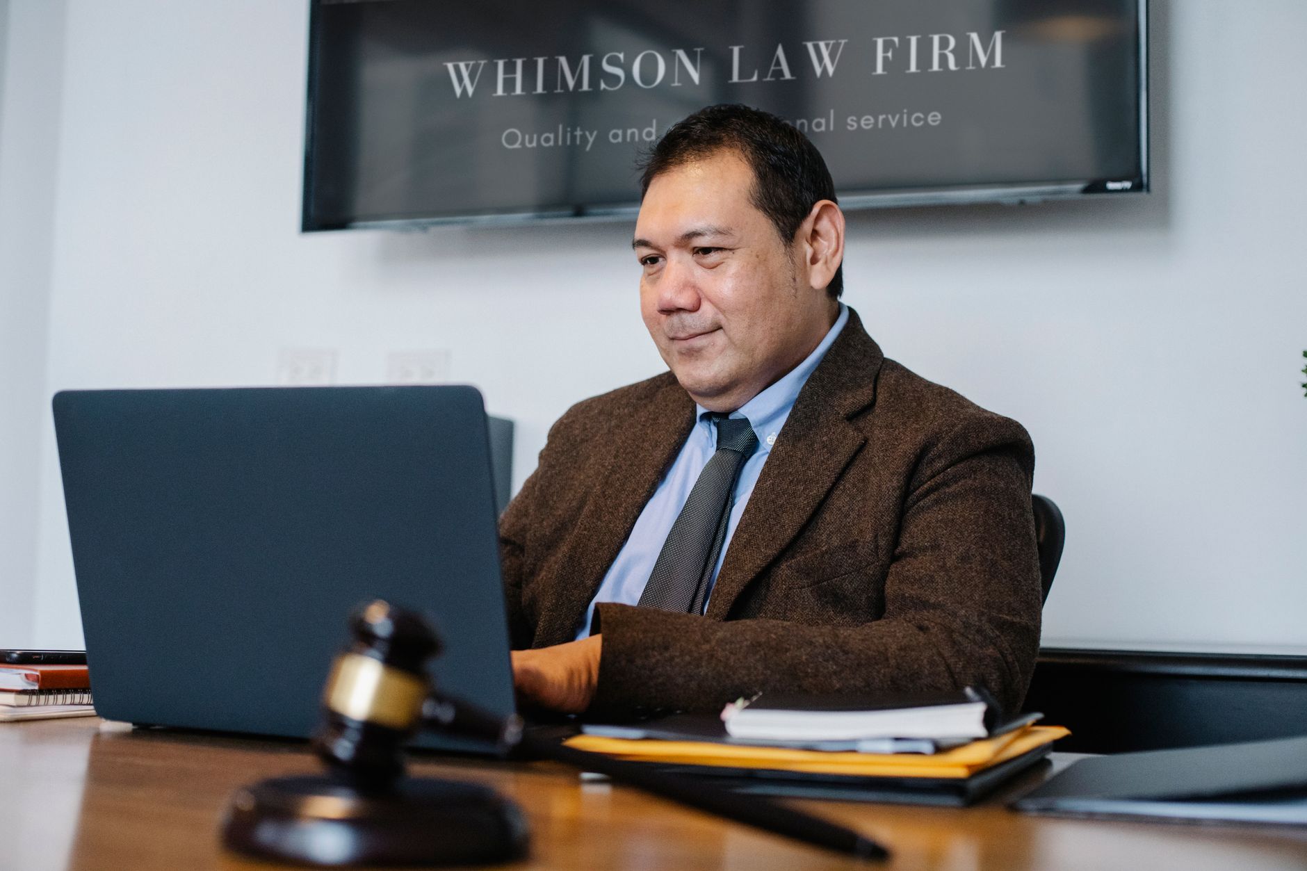 Professionnel du droit travaillant sur ordinateur portable, marteau de juge posé sur le bureau